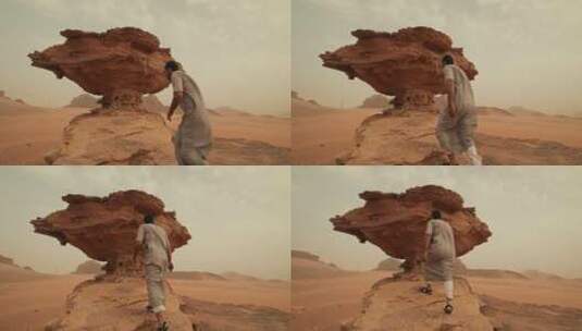 在沙漠悬崖上行走的阿拉伯人高清在线视频素材下载