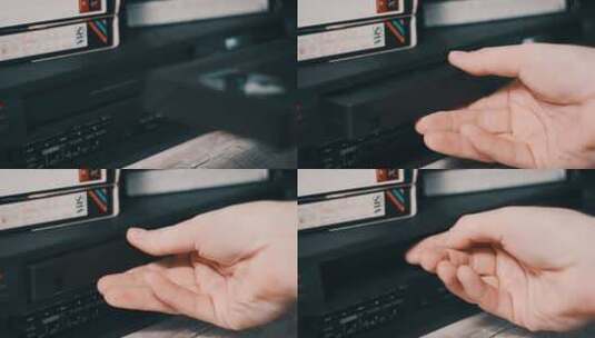 男性手将VHS磁带插入VCR视频播放器高清在线视频素材下载