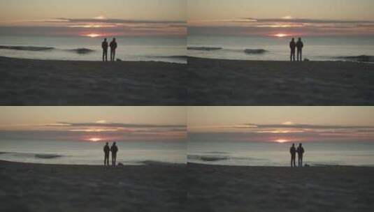 两个朋友站在沙滩上看日落高清在线视频素材下载