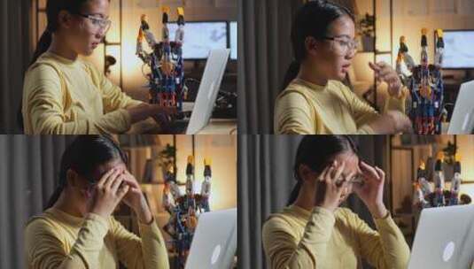特写的青少年亚洲女孩有一个头痛而工作关于一个机器人手在笔记本电脑上在家里高清在线视频素材下载