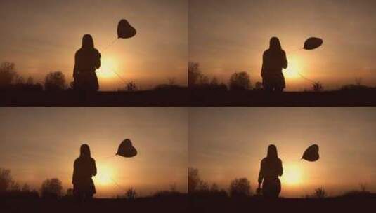 年轻女孩拿着气球进入夕阳的光辉高清在线视频素材下载