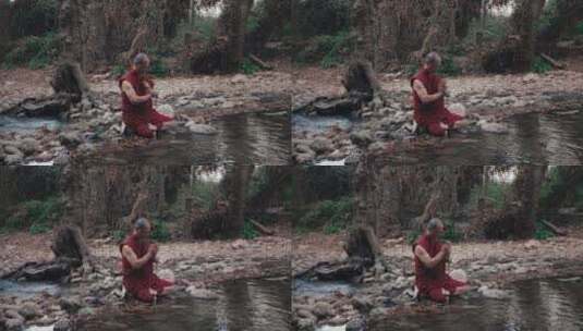 和尚坐在森林的小溪边祈祷高清在线视频素材下载