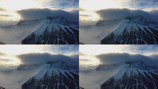 阳光照耀下云雾缭绕的雪山景观高清在线视频素材下载