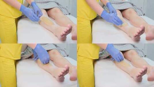 美容师在客户腿上涂抹美容蜡高清在线视频素材下载