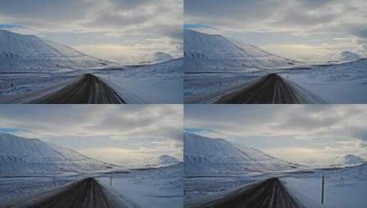 在午夜的阳光下，沿着冰岛一条荒芜、白雪覆盖的山路行驶。高清在线视频素材下载
