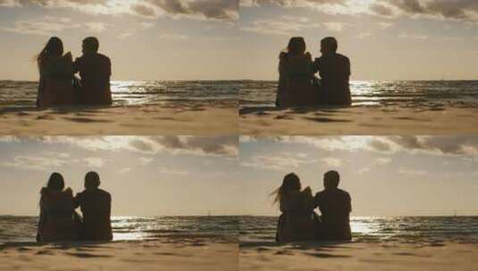 情侣坐在海滩上欣赏日落高清在线视频素材下载