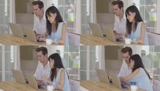 夫妇坐在桌子旁使用笔记本电脑高清在线视频素材下载