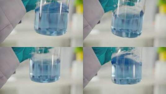 实验人员晃动观察烧杯中的蓝色溶液高清在线视频素材下载