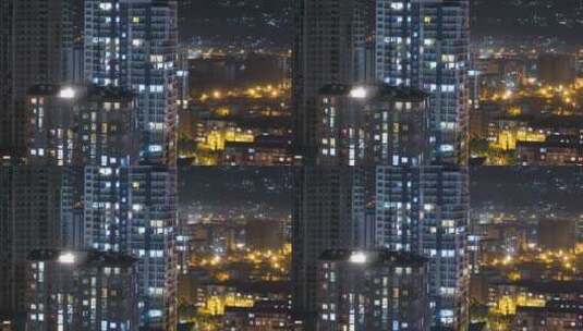 城市中具有夜间变化窗户照明的多层建筑，延时高清在线视频素材下载