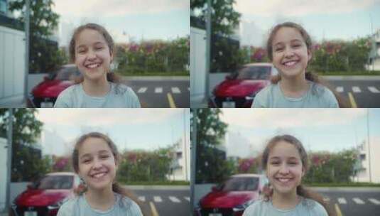 肖像快乐的孩子积极的小女孩在街上靠近房子高清在线视频素材下载