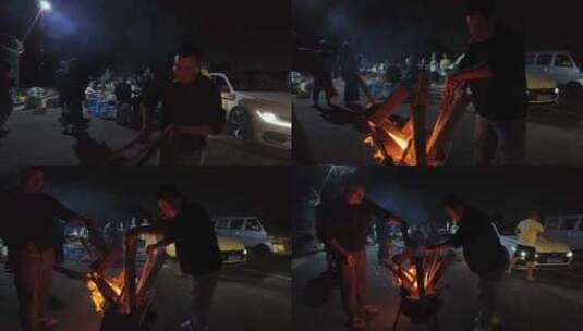 两位男子往篝火炉添加木柴高清在线视频素材下载