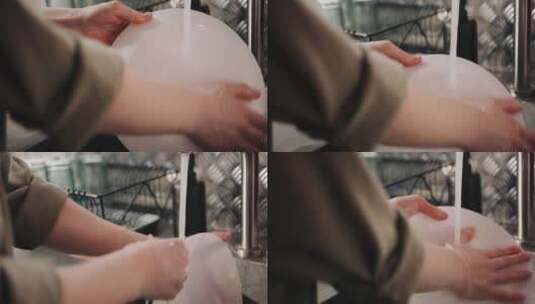 一位妇女用自来水冲洗盘子高清在线视频素材下载