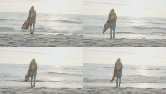 年轻女子站在海边遥望远方的背影。孤独的女性享受海滩。高清在线视频素材下载