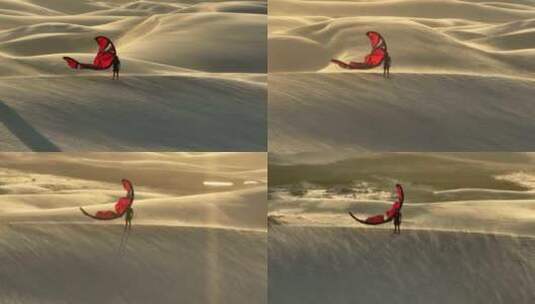 一个拿着红色风筝的人站在沙丘上，在刮风的日子里看着巴西的沙漠高清在线视频素材下载