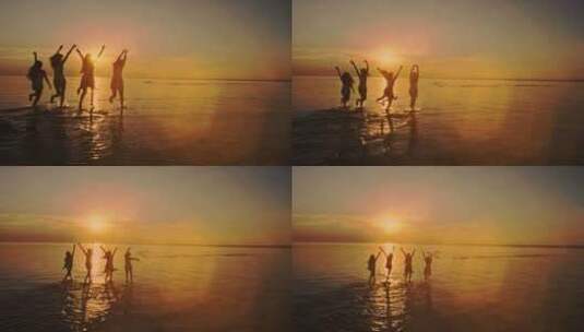 四个十几岁的女孩跑进水里，在日落时分的海滩上庆祝。海滩派对。太阳高清在线视频素材下载