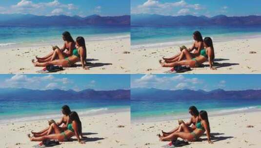 两个女孩坐在异国情调海滩的白沙上计划她们的旅行，阅读信息传单高清在线视频素材下载