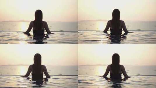 日落时，无边泳池中俯瞰海中船只的女人剪影高清在线视频素材下载