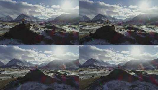 孤独的登山者在雪山上休息，高高的云层映入阳光下，登山者伸手高清在线视频素材下载