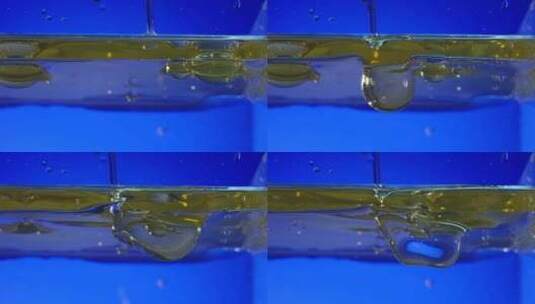 蓝色背景下工业油液体滴落高清在线视频素材下载