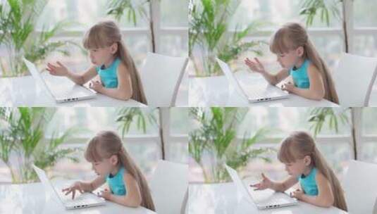 小女孩在桌子上用笔记本电脑高清在线视频素材下载