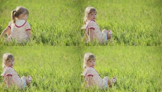 小女孩做在草地上看镜头高清在线视频素材下载