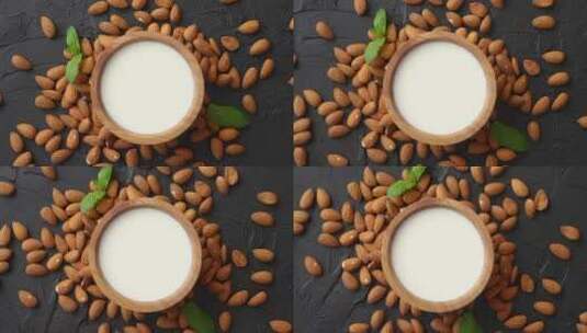 木碗里的新鲜杏仁牛奶和黑色石头背景上的杏仁高清在线视频素材下载
