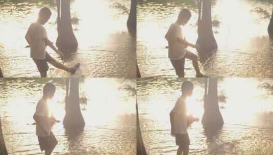 小男孩在傍晚夕阳下的水池边玩耍视频素材高清在线视频素材下载
