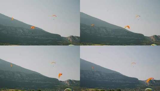 人们在山脉上空用滑翔伞飞行高清在线视频素材下载