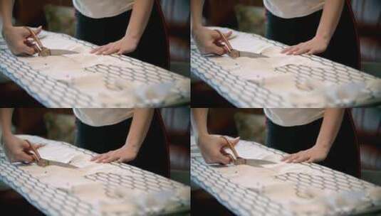 年轻女子用剪刀剪裁白色布料高清在线视频素材下载