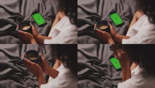 女人坐在床上喝咖啡玩手机高清在线视频素材下载