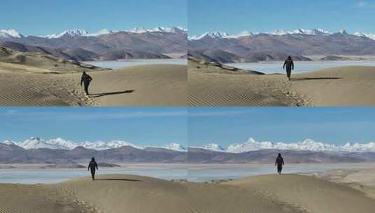 西藏沙漠湖泊雪山人物行走航拍高清在线视频素材下载