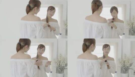 年轻女人对着镜子梳头高清在线视频素材下载