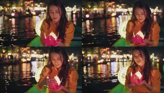 会安夜市，快乐的亚洲女孩在船上举着蜡烛高清在线视频素材下载