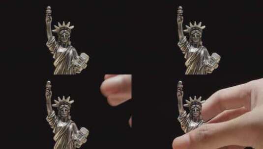手工挑选一个黑色背景的自由女神像复制品。高清在线视频素材下载