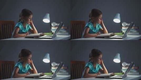 女孩晚上在桌子上读课本高清在线视频素材下载
