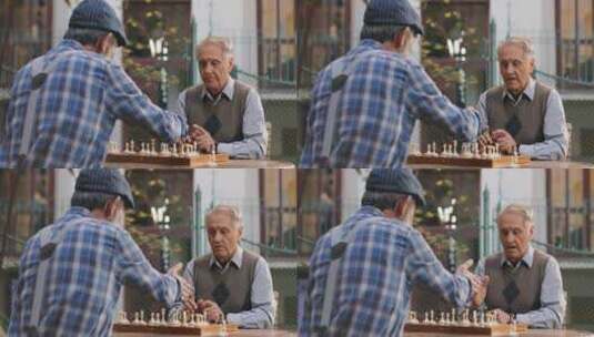 退休老人围着桌子下国际象棋  高清在线视频素材下载