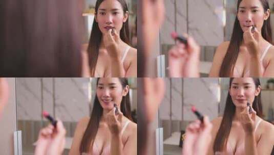 美丽的年轻亚洲女人涂口红粉色高清在线视频素材下载