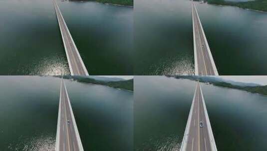 穿越机航拍新能源汽车行驶在湖面大桥上高清在线视频素材下载