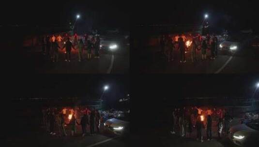 晚上围在篝火围成一圈手拉手边跳舞的人高清在线视频素材下载