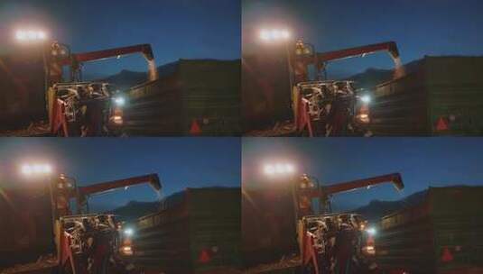 联合收割机夜间将粮食倾倒在拖拉机拖车中高清在线视频素材下载