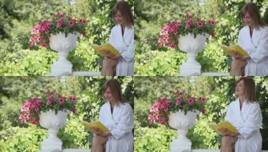 女人穿着浴袍在花园里看书高清在线视频素材下载