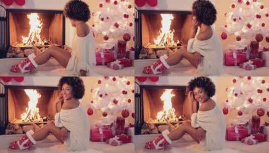 女孩在圣诞树旁壁炉取暖高清在线视频素材下载