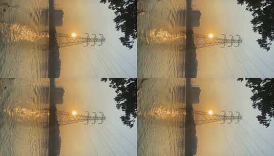日落下的供电塔和湖水倒影高清在线视频素材下载