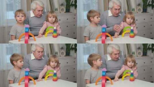 爷爷玩玩具与孙子和小孙女室内老人爷爷一起高清在线视频素材下载