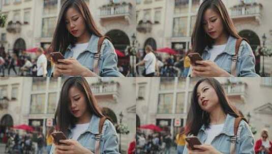 女人在街头玩手机高清在线视频素材下载