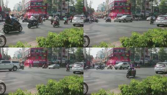 固定镜头拍摄路口行驶的摩托车和汽车高清在线视频素材下载