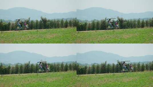 一家人骑着四轮自行车在京道安城农地游览高清在线视频素材下载