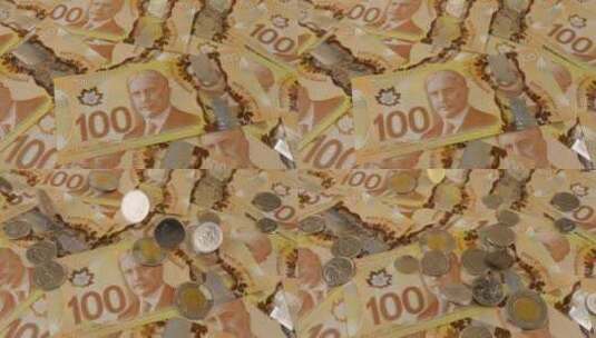 100美元聚合物纸币上掉落的加拿大硬币，上面有罗伯特·博登的肖像。慢动作高清在线视频素材下载