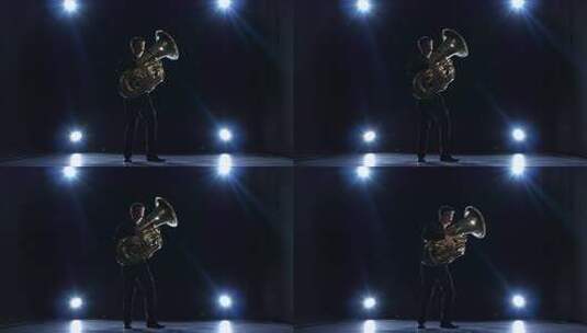 聚光灯下黑暗工作室的音乐家演奏大号慢速爵高清在线视频素材下载