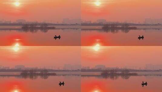 夕阳下的湖面小船剪影及岸上城市建筑剪影高清在线视频素材下载